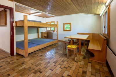 Kleiner Schlafraum mit Doppelstockbett und Eckbank